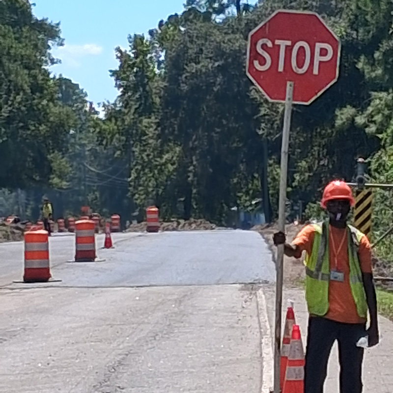 Adult male construction worker stopping traffic